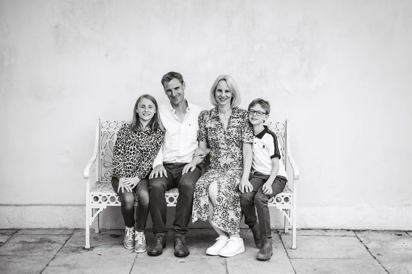 Family sitting together on a bench during a portrait session