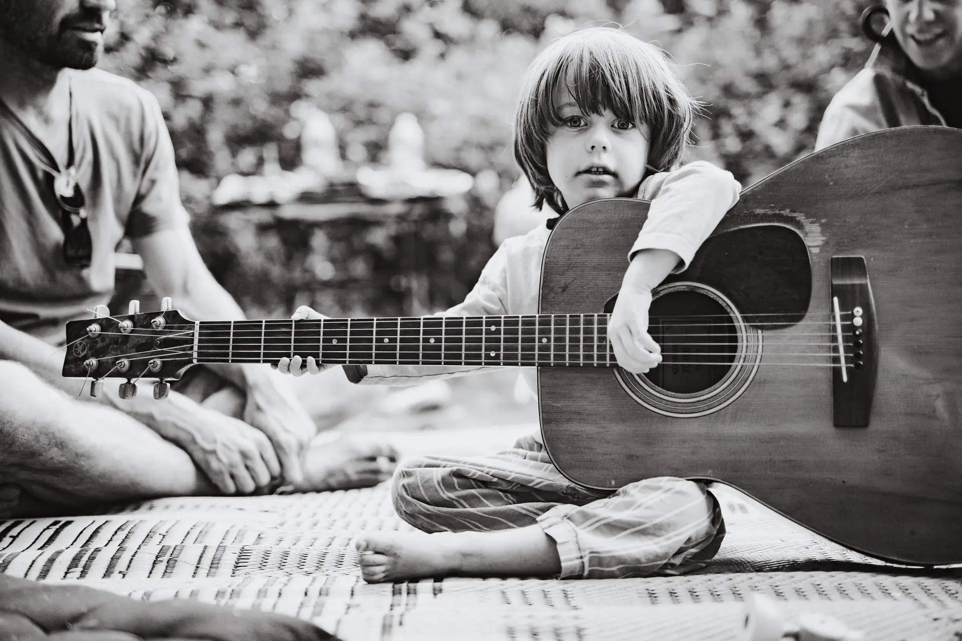 Boy playing an acoustic guitar during an outdoor family session