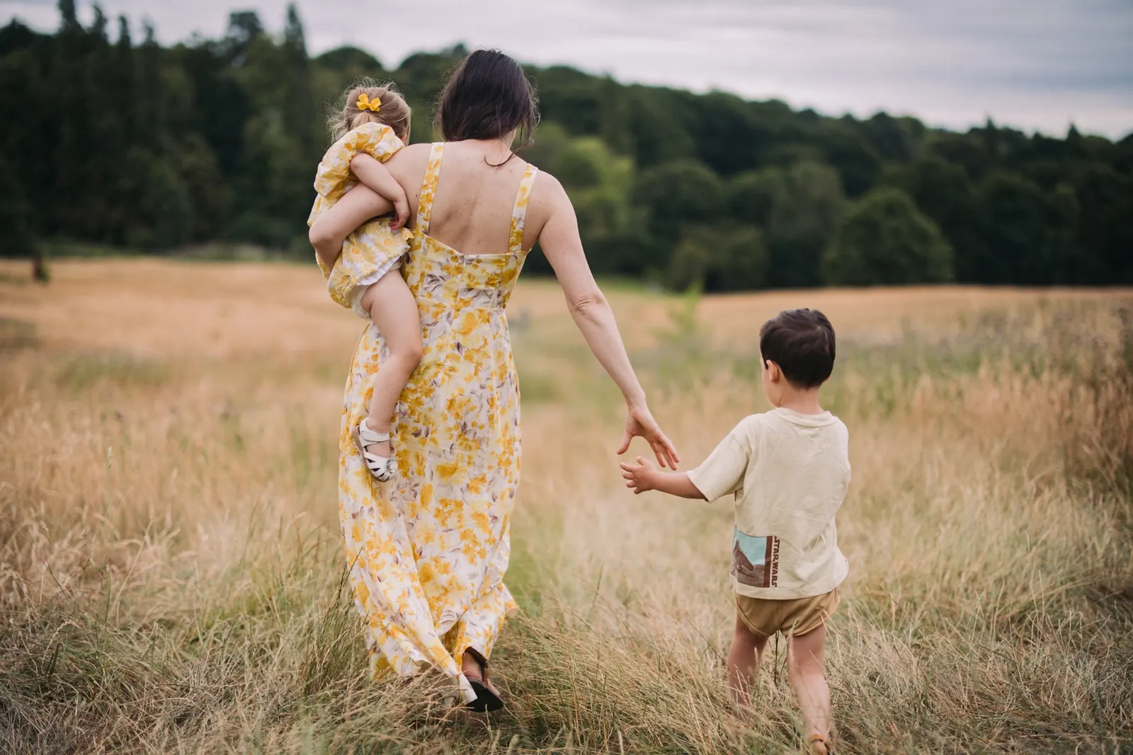 Mother walking with children through a meadow