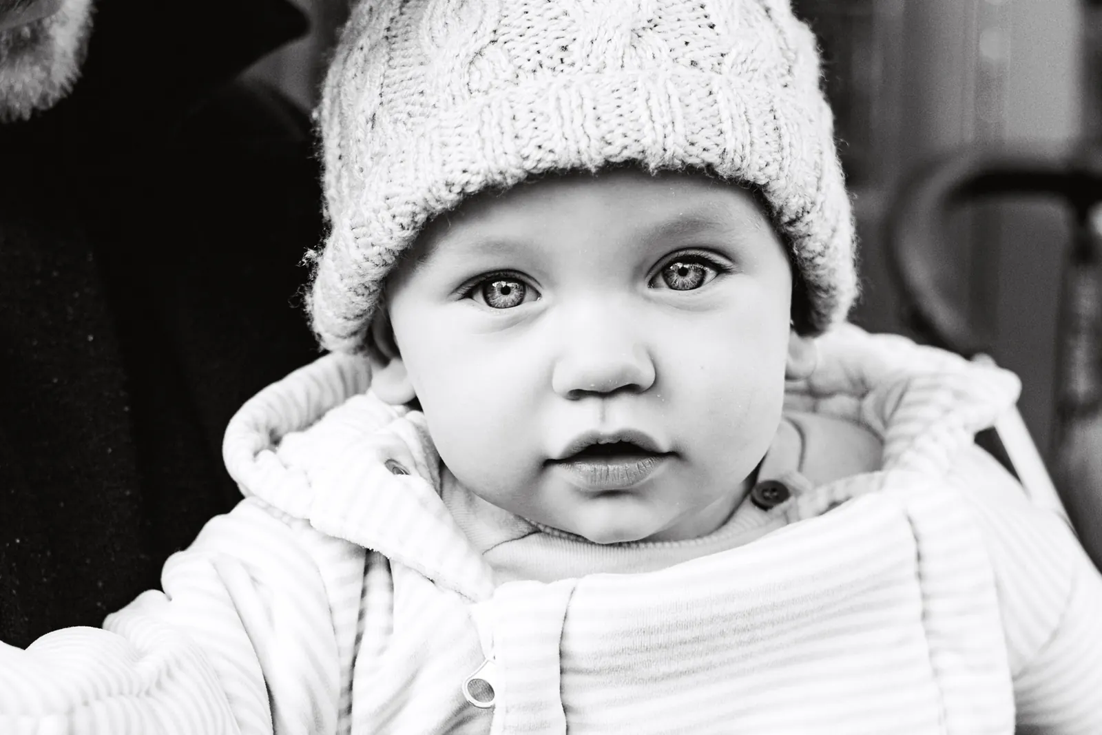 Baby in a knitted hat, black and white portrait
