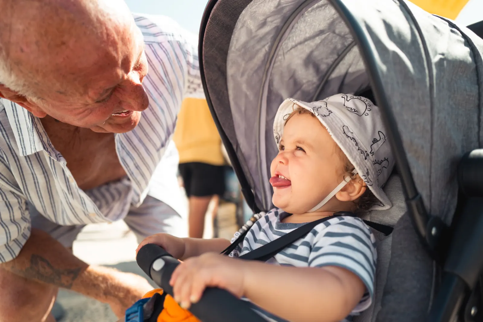 Grandad talking to grandchild in pushchair