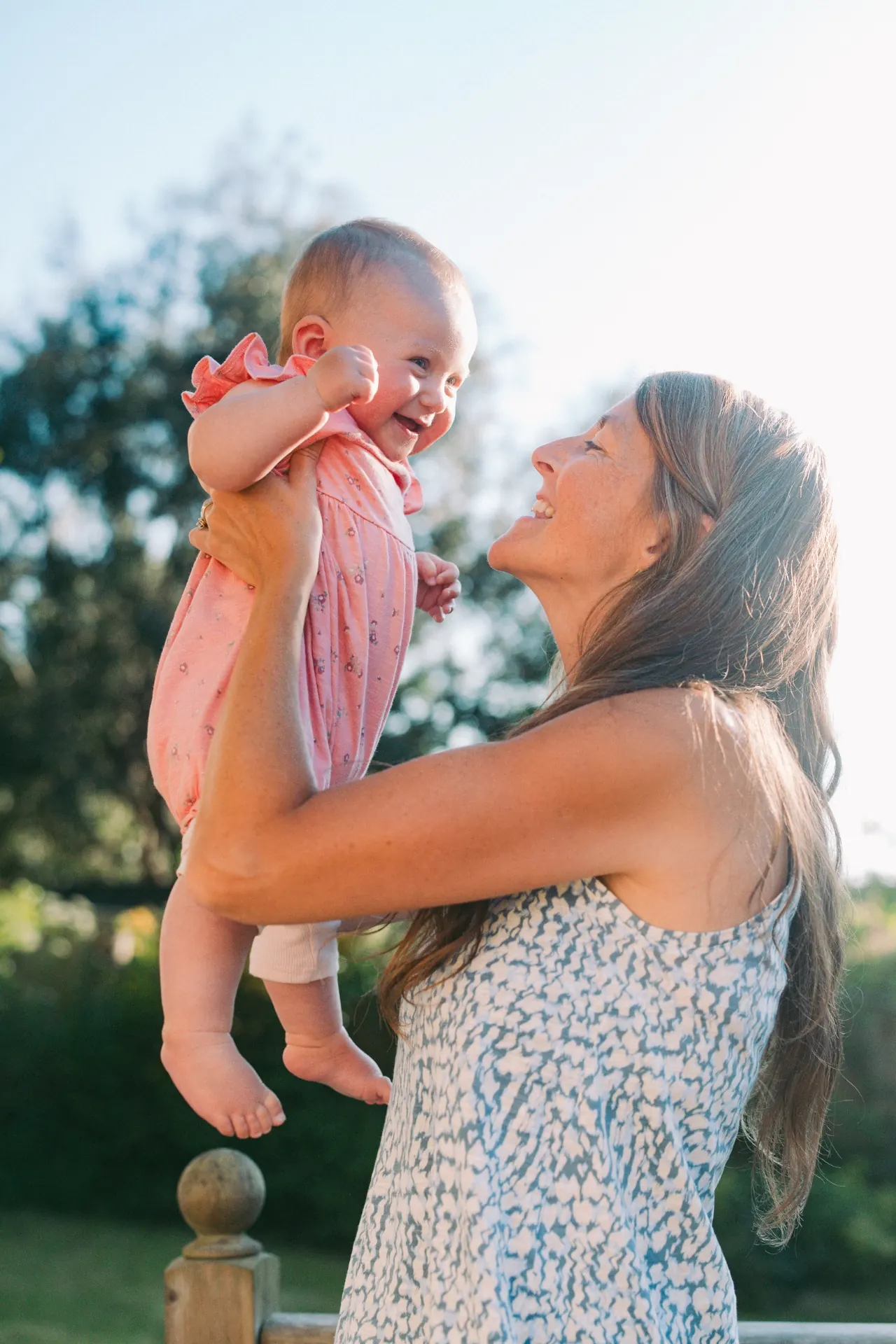 Grandmother lifting laughing baby in the garden