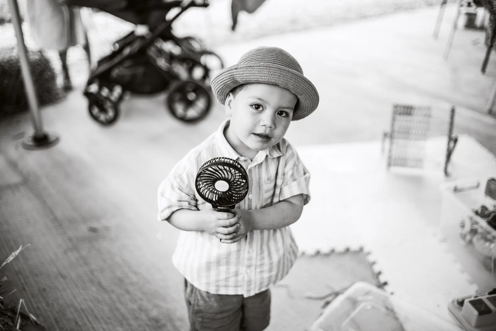 Toddler with sun hat holding a small fan