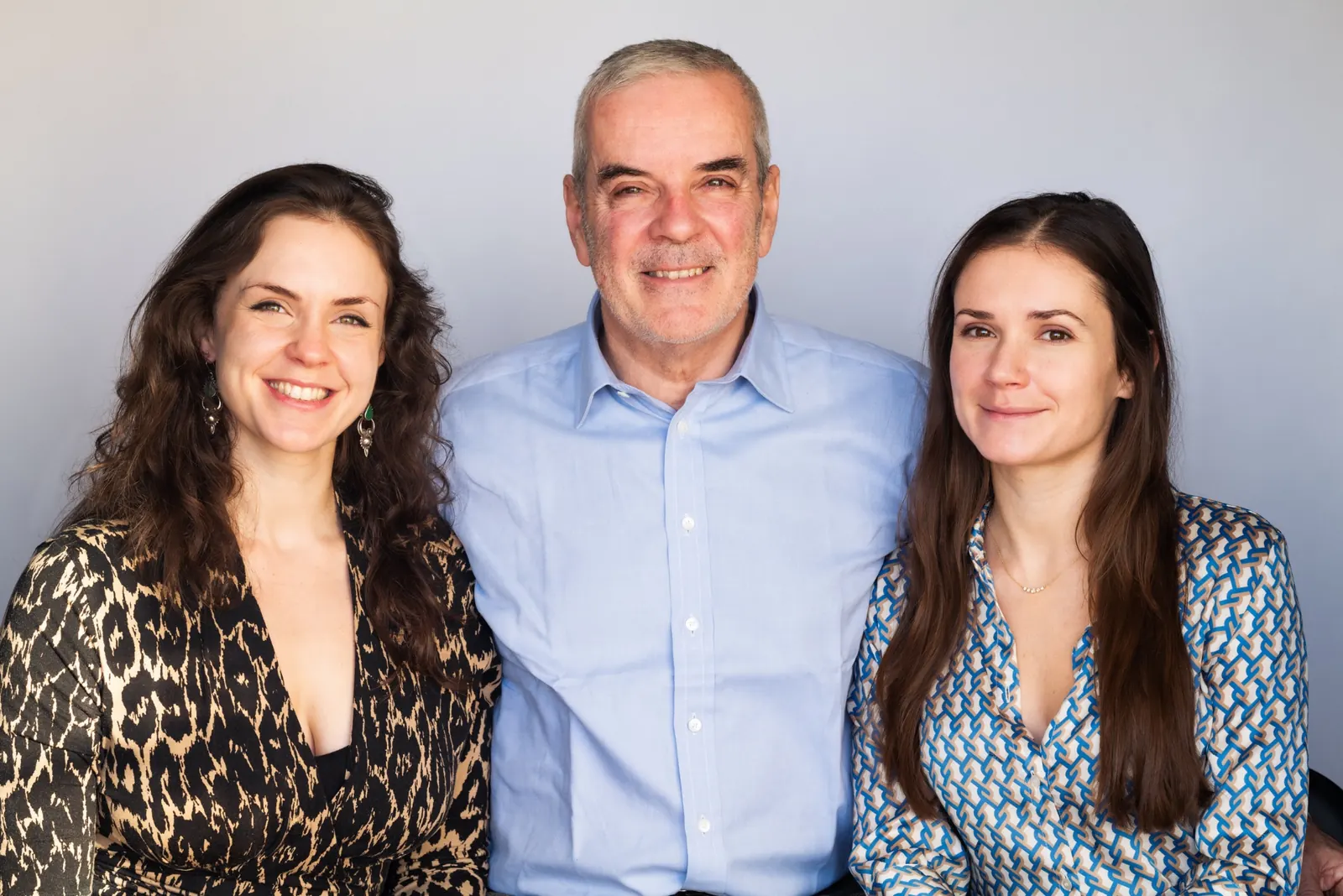 Father and two daughters studio portrait smiling