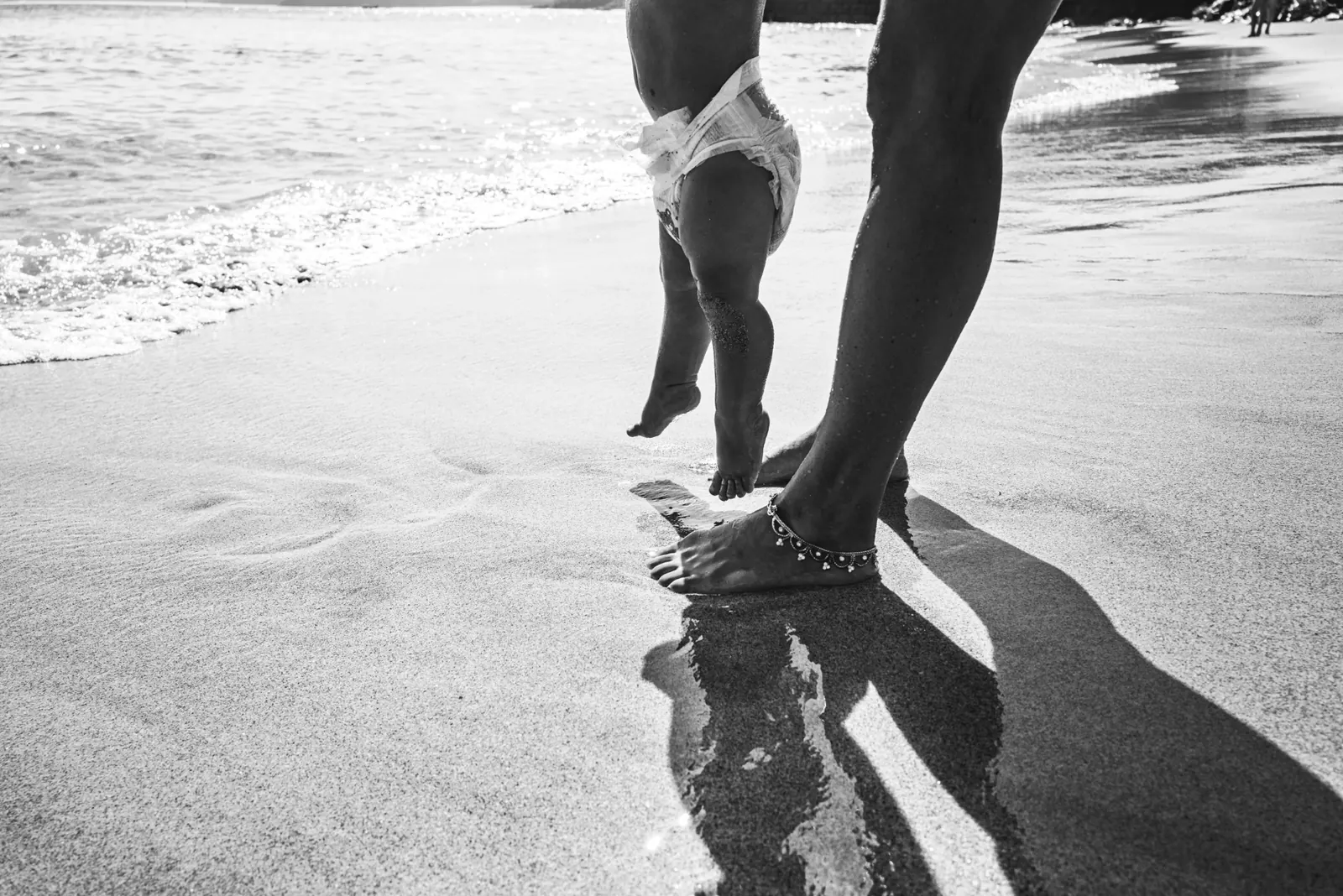 Mother and baby walking on the beach