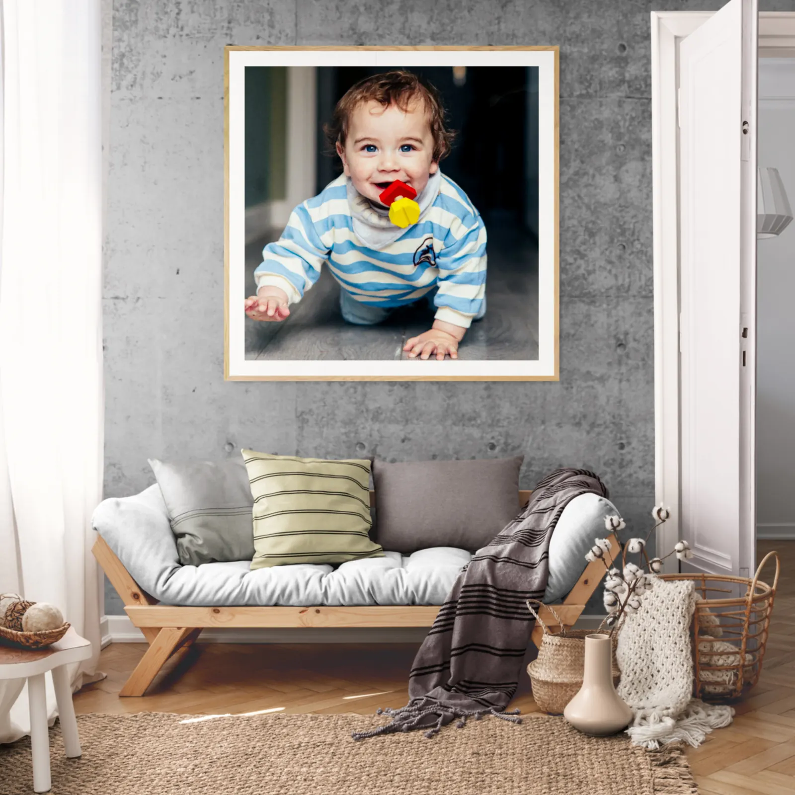 Framed portrait of a smiling toddler displayed on a living room wall above a sofa