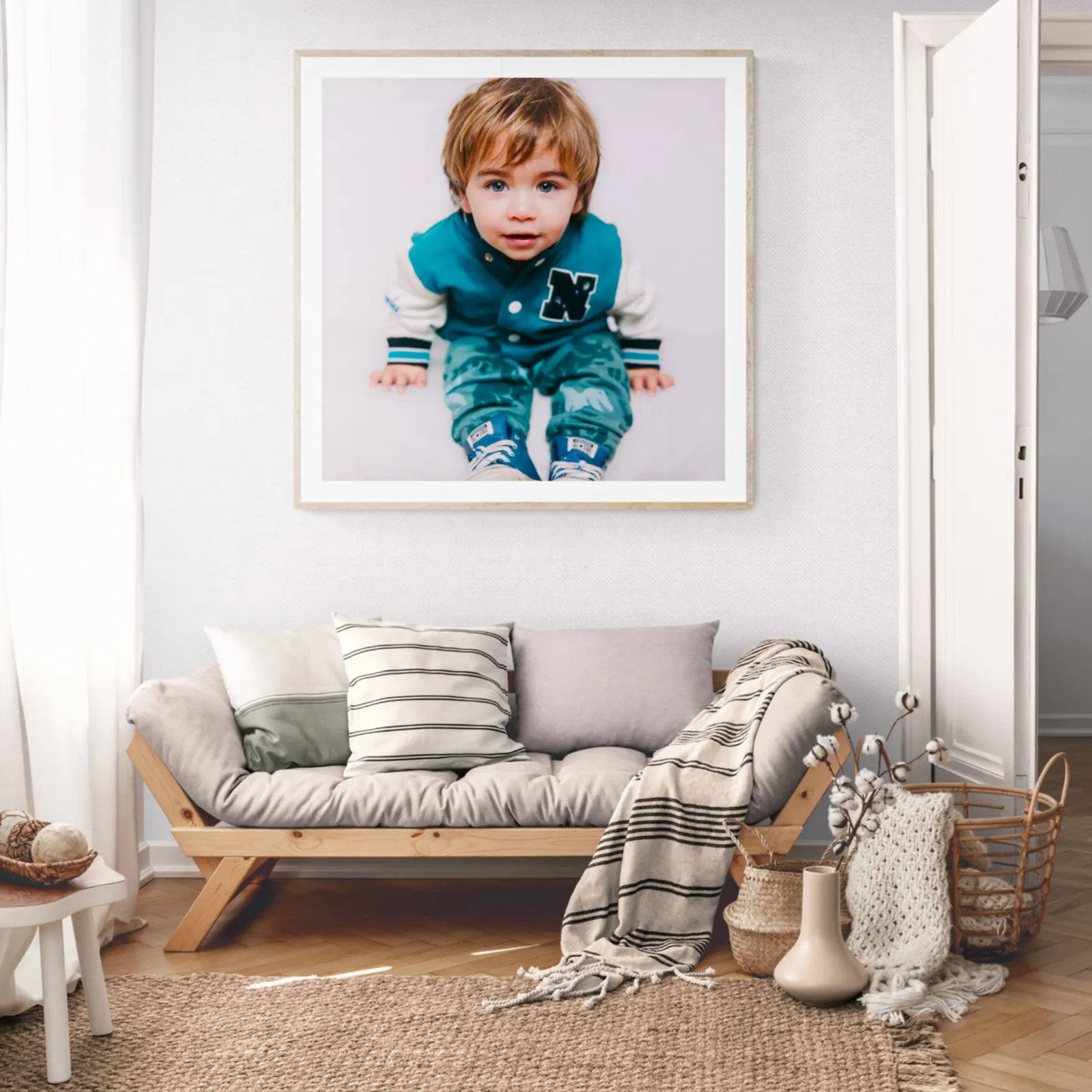 Framed family portrait hanging above a sofa in a bright, styled living room